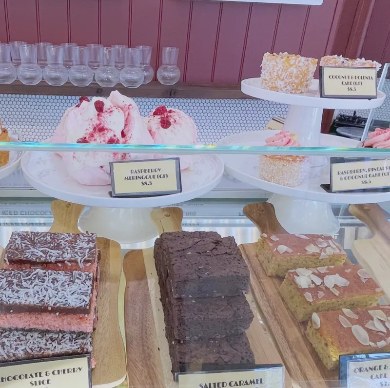 Slices and meringues on cake stands in the cabinet
