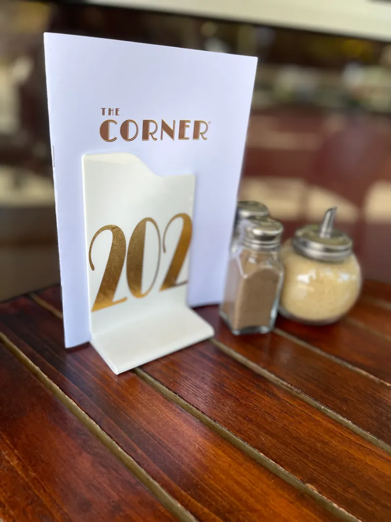 A gold numbered table card in the Corner's Art Deco lettering